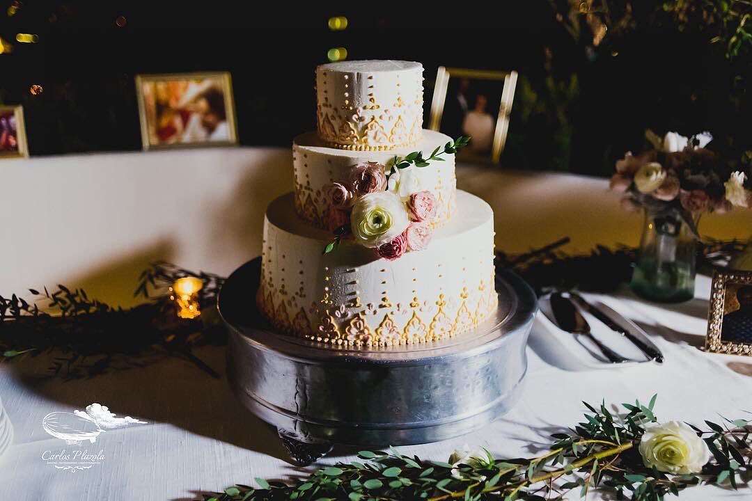 three tiered wedding cake with intricate piping