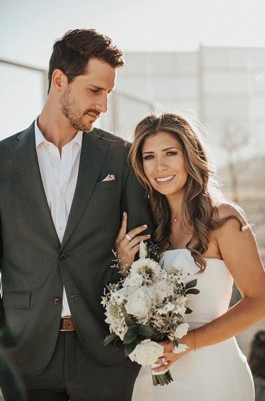groom and bride holding white bridal bouquet