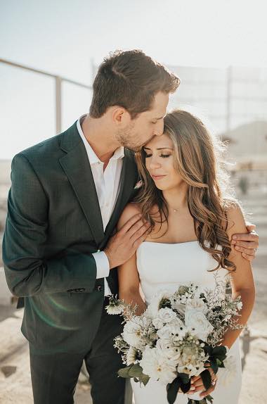 groom kissing bride's forehead